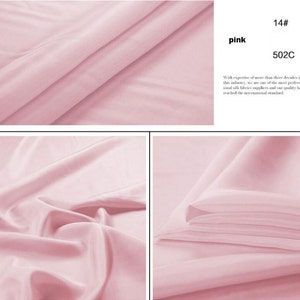 May include: A close-up of a soft, pink fabric. The fabric is smooth and silky. The fabric is folded in half and the edges are visible. The fabric is a light pink color. 14# pink 502C