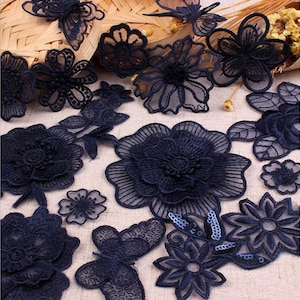 May include: Assortment of navy blue lace appliques in various floral and butterfly designs. The appliques are delicate and intricate, perfect for adding a touch of elegance to clothing, accessories, or home decor projects.