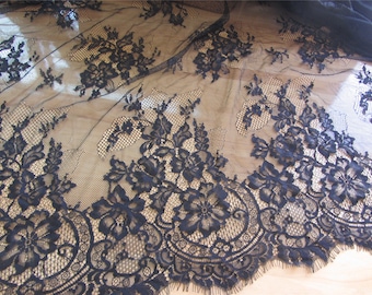 May include: Black lace fabric with a floral pattern. The lace is delicate and has a scalloped edge.