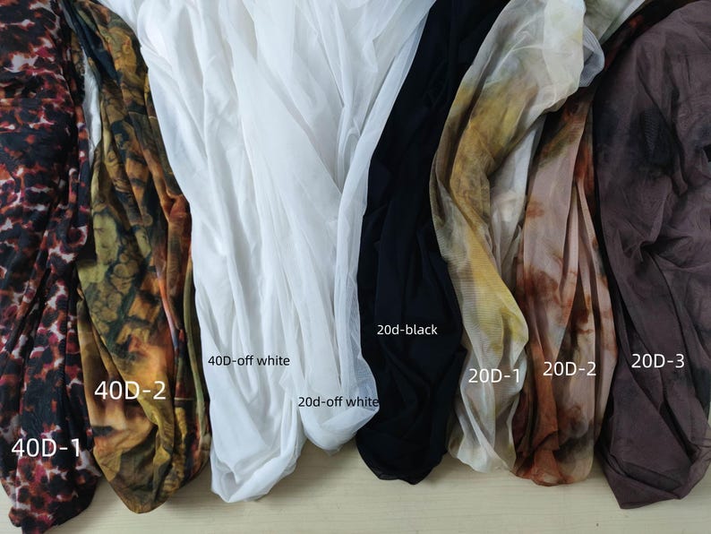 Peut inclure: Assortiment de tissus transparents de diff&eacute;rentes couleurs et motifs. Comprend des imprim&eacute;s animaliers, des motifs abstraits, du blanc, du noir et du marron. Chaque tissu est &eacute;tiquet&eacute; avec son denier et sa couleur, comme "20d-black".