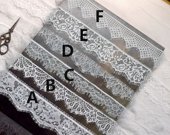 May include: A close-up of six different white lace trims, labeled A through F, on a wooden surface. The lace trims have various patterns and widths.