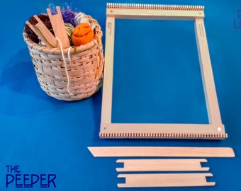 May include: A wooden loom with a basket of yarn and weaving tools. The loom is labelled "Lost Pond Looms".