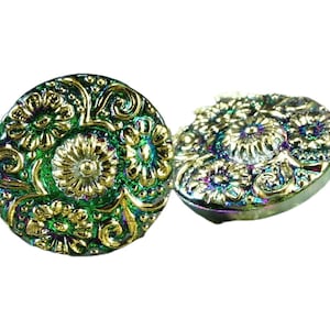 Può includere: Due bottoni verdi e dorati iridescenti con un motivo floreale. I bottoni hanno un motivo in rilievo.