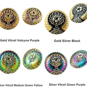 Op de afbeelding: Assortiment van decoratieve glazen knopen met een reliëf bloemmotief. De knopen zijn iriserend in verschillende kleuren, waaronder goud, zilver, paars, groen en zwart.