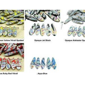 Könnte beinhalten: Sortiment aus Glasperlen in verschiedenen Farben, darunter Zitronengelb, Schwarz, Alabasterweiß, Rubinrot und Aquablau. Die Perlen haben ein einzigartiges Vitrail-Muster mit irisierenden Akzenten.