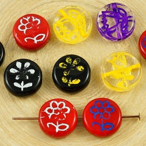 May include: Assortment of round glass beads with various floral designs. The beads are in red, black, yellow, and purple with white accents.