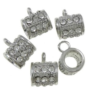Peut inclure: Cinq embouts de perles en métal argenté avec des accents de strass transparents. Chaque embout a une boucle pour l'attacher à un collier ou un bracelet.