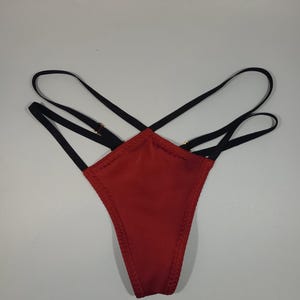 May include: Red and black lingerie with criss-cross straps.
