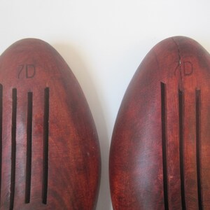 Puede incluir: Un par de estiradores de zapatos de madera marr&oacute;n con un dise&ntilde;o acanalado. Los estiradores de zapatos est&aacute;n etiquetados como "7D" y "7D".