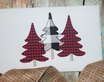 Könnte beinhalten: Drei Weihnachtsbäume aus Stoff mit einem rot-schwarzen Karomuster. Der mittlere Baum ist aus schwarz-weißem Buffalo-Karomuster. Die Bäume befinden sich auf einem weißen Hintergrund.