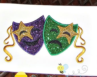 May include: Two glittery masks, one purple and one green, with gold stars and curly gold accents. The masks are a happy face and a sad face.