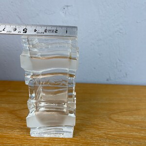 May include: A clear glass vase with a geometric design. The vase is made of multiple stacked squares and is approximately 5 inches tall.