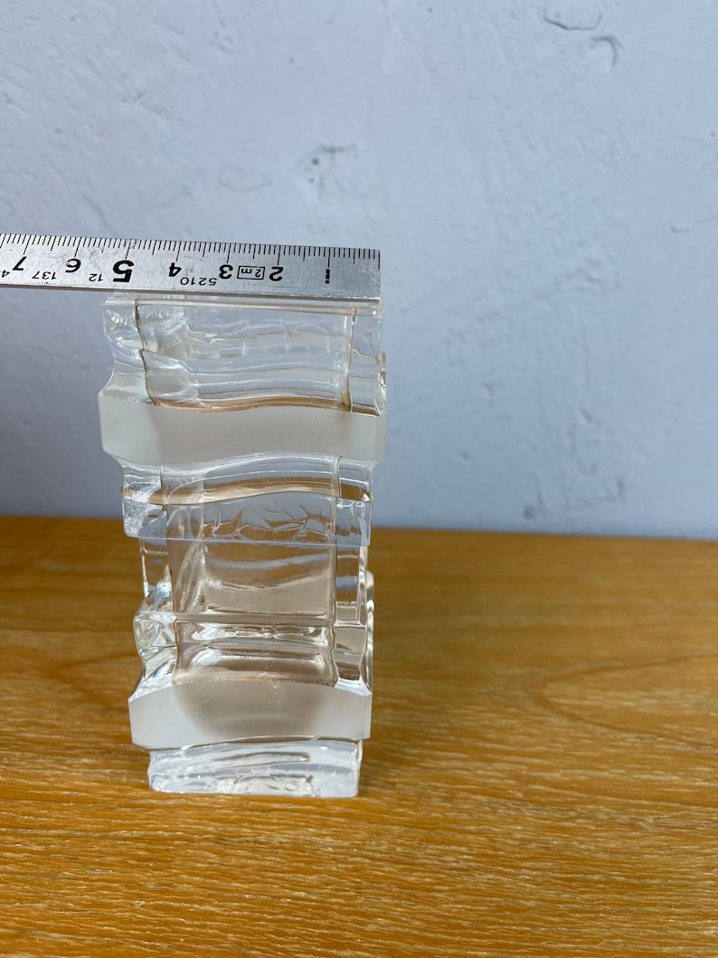 May include: A clear glass vase with a geometric design. The vase is made of multiple stacked squares and is approximately 5 inches tall.