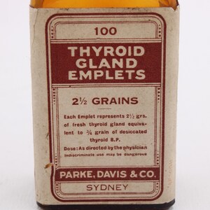 May include: An antique medicine bottle label for "Thyroid Gland Emplets." The label is primarily brown and cream-colored, with text in a vintage font. It includes the dosage information and the manufacturer's name, Parke, Davis & Co., Sydney.