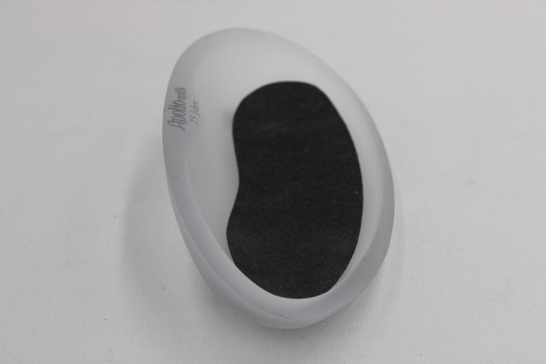 K&ouml;nnte beinhalten: Oval geformte Schale aus mattiertem Glas mit schwarzem Innenraum. Die Schale hat ein glattes, geschwungenes Design und eine matte Oberfl&auml;che. Der Text "Apollo art 25 Jahre" ist auf der Seite aufgedruckt.