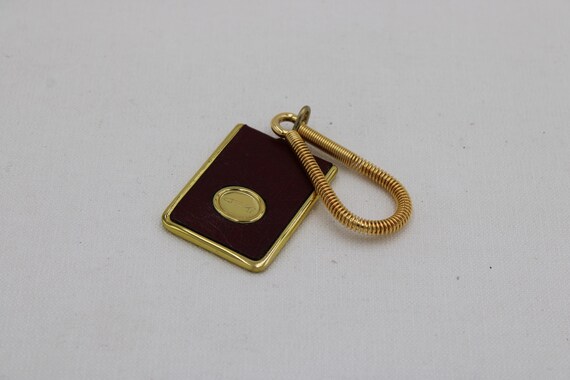 Eleganter Vintage Schlüsselanhänger aus bordeauxfarbenem Leder mit goldfarbener Metallfassung | Klassisches Sammlerstück