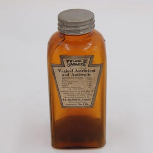 May include: An amber-colored glass bottle with a gray metal cap. The bottle has a label that reads "FRIABLE TABLETS Vaginal Astringent and Antiseptic." The label also lists ingredients and the manufacturer, K.K. Mulford Co., Philadelphia.