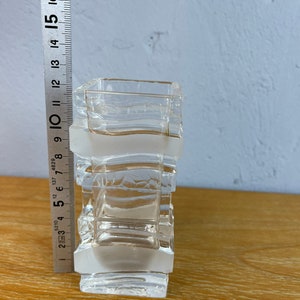 May include: A clear glass vase with a frosted finish and a geometric design. The vase is approximately 10 inches tall.