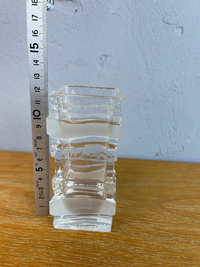 May include: A clear glass vase with a frosted finish and a geometric design. The vase is approximately 10 inches tall.