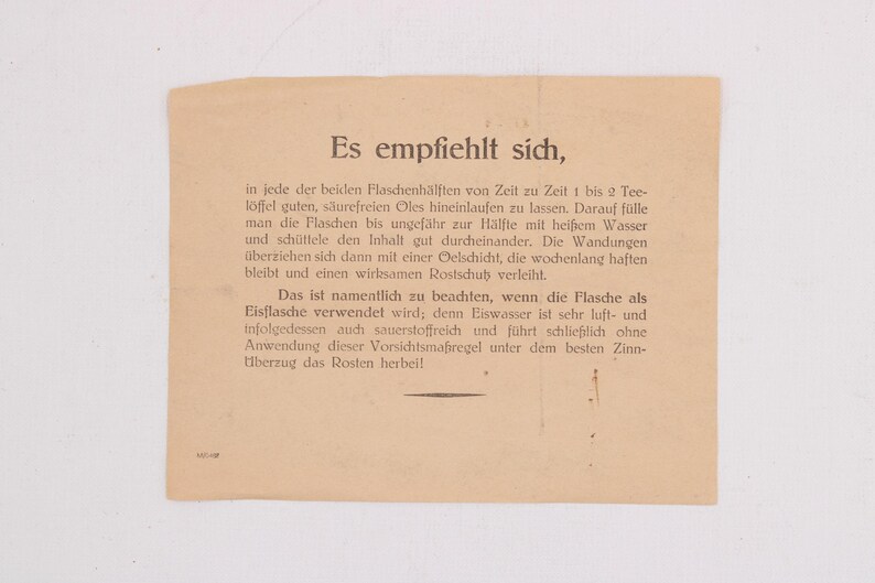 May include: A vintage, tan-colored paper with German text. The text is in a serif font and appears to be instructions or a guide. The paper is slightly aged, with a few small imperfections.