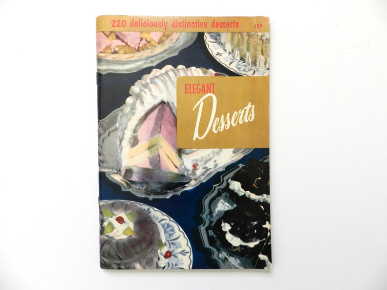 May include: Vintage cookbook titled "Elegant Desserts" with a cover showing illustrations of various desserts on silver platters. The cover has a gold banner with the title in script and the text "220 deliciously distinctive desserts".