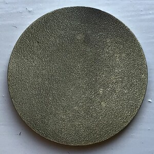 K&ouml;nnte beinhalten: Eine runde, silberfarbene Metallscheibe mit einer strukturierten Oberfl&auml;che.
