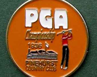 Könnte beinhalten: Orangefarbener und weißer PGA Championship 1986-Pin mit einem Golfer in rot-schwarzer Kleidung. Der Pin zeigt auch Pinehurst Country Club.