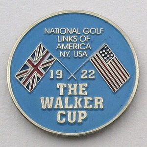 Könnte beinhalten: Eine runde, blaue Golf-Gedenkmünze mit dem Text "NATIONAL GOLF LINKS OF AMERICA NY, USA" und "THE WALKER CUP 19 22". Zeigt die Flaggen der Vereinigten Staaten und des Vereinigten Königreichs.