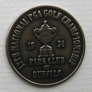 Könnte beinhalten: Eine bronzene Gedenkmünze mit der Aufschrift "17th National PGA Golf Championship 1934 Park Club of Buffalo" und einer Darstellung einer Trophäe.