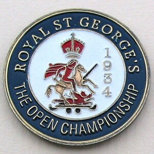 Könnte beinhalten: Eine goldene und blaue runde Anstecknadel mit dem Text "Royal St. George's The Open Championship 1934" am Rand. Die Mitte zeigt einen weißen Hintergrund mit einem roten und goldenen Bild von St. Georg, der einen Drachen tötet.