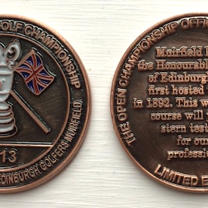 Op de afbeelding: Een herdenkingsmunt van het 142e Open Golf Championship, Muirfield 2013. De munt toont de Open Championship trofee, gekruiste vlaggen en tekst. De achterkant beschrijft de geschiedenis van de Open.