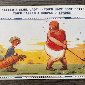 May include: Vintage postcard with a golf theme. The image features a cartoon of a golfer swinging a club, with a caddy nearby. The text reads, "YOU CALLED A CLUB, LADY...YOU'D HAVE DONE BETTER IF YOU'D CALLED A COUPLE O' SPADES!"