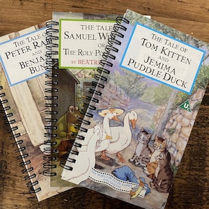 May include: Three spiral bound notebooks with illustrations from Beatrix Potter's children's books. The covers feature "The Tale of Peter Rabbit", "The Tale of Samuel Whiskers or The Roly-Poly Pudding", and "The Tale of Tom Kitten and Jemima Puddle-Duck".