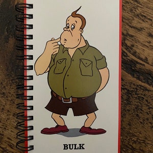May include: A cartoon illustration of a person with a large belly, wearing a green short-sleeved shirt, brown shorts, and red shoes. The word "BULK" is printed below the cartoon.
