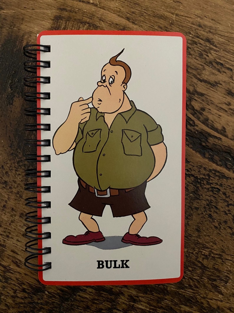 May include: A cartoon illustration of a person with a large belly, wearing a green short-sleeved shirt, brown shorts, and red shoes. The word "BULK" is printed below the cartoon.