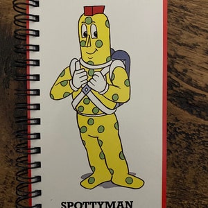 May include: A yellow character with green spots and a red hat, wearing a white and green suit. The character is standing with arms crossed and the text "SPOTTYMAN" is below the character.