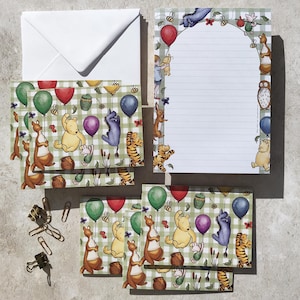 May include: Stationery set featuring Winnie the Pooh characters. Includes an envelope, notepaper, and notecards with a green and white checkered pattern. The illustrations include balloons, honey pots, and various characters like Pooh, Tigger, and Roo.