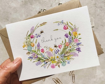 Tarjetas y sobres de agradecimiento plegados para boda con corona de flores de primavera