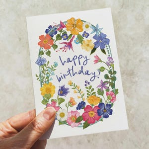 Tarjeta y sobre de feliz cumpleaños con flores festivas brillantes y coloridas