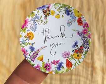 Könnte beinhalten: Runder Aufkleber mit einem Blumendesign mit Schmetterlingen und dem Text "Danke".
