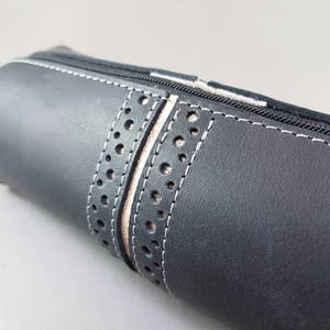 Cassa Rouxie nera con decoro in pelle dorata.