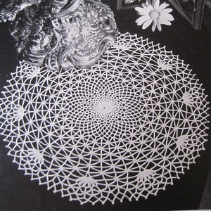 May include: A white crocheted doily with a circular design. The doily has a delicate, intricate pattern with a central motif.