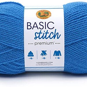May include: A ball of Lion Brand Basic Stitch Premium yarn in a bright blue colour. The label reads "Basic Stitch...premium..." and shows suggested projects like a hat, scarf, and sweater.
