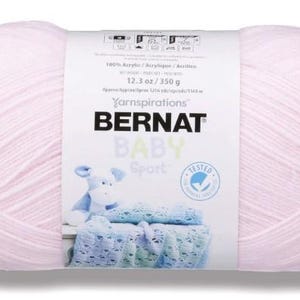 May include: A pink ball of Bernat Baby Sport yarn, a 100% acrylic yarn, with a label that reads "Yarnspirations Bernat Baby Sport 12.3 oz / 350 g"