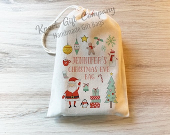 May include: A white Christmas Eve gift bag with a red and white Santa Claus, a snowman, a gingerbread man, and a Christmas tree. The bag is decorated with a red and white candy cane, a red mug, and a green and white Christmas ornament. The text on the bag reads "Jennifer's Christmas Eve Bag".