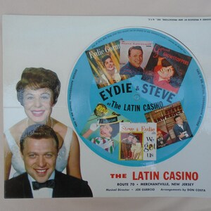 Könnte beinhalten: Eine Werbe-Schallplattenhülle mit Eydie Gormé und Steve Lawrence im Latin Casino. Das Design enthält eine hellblaue kreisförmige Grafik mit sechs kleinen Albumcovern, dem Text Eydie & Steve at The Latin Casino sowie Angaben zum Veranstaltungsort.