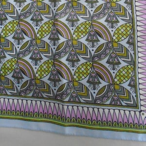 May include: A square scarf featuring a repeating geometric pattern of stylized bell-shaped flowers in shades of olive green, grey, and soft pink on a light blue background, finished with a decorative border of pink and green pointed petals.