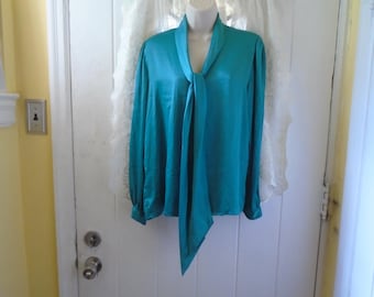 May include: A teal blue satin blouse with a long, flowing tie at the neck. The blouse has long sleeves and a relaxed fit.