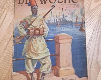 May include: Vintage magazine cover featuring a soldier in a white uniform and red hat, holding a rifle. The cover has the title "DIE WOCHE" and the text "Italienisch Tripolis". The background shows a harbor scene with boats.