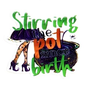May include: A sticker featuring a purple skirt, orange polka-dot tights, and black shoes next to a dark cauldron. The text reads Stirring the pot since birth in green and orange lettering, with a small spider graphic near the cauldron rim.